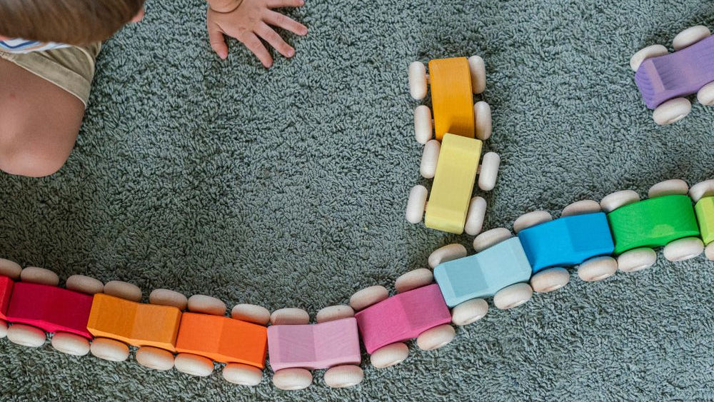 Child playing with colorful building blocks on a carpeted floor
